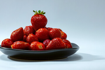 Juicy seasonal strawberries close up macro texture on a black plate