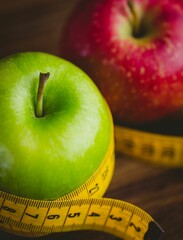 Red and green apples with measuring tape