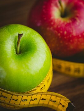 Fototapeta Red and green apples with measuring tape