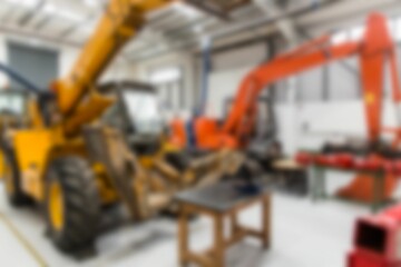 Flat design showing workshop with yellow backhoe loader raising bucket, robotic arm, crane rails