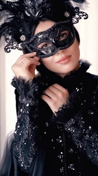 A captivating woman with dark hair gazes alluringly, partially concealing her face with an elegant black Venetian mask adorned with delicate lace and feathers.
