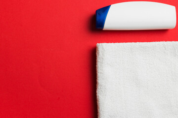 Cosmetic shampoo bottle mockup with towels on a colored table. Bathroom background, toilet...