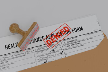 Denied health insurance application form on the table. Document with denied stamp put on the ...