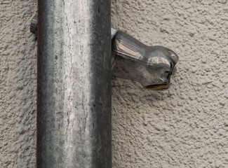 Unique glass ornament resembling a hand grasping a metal pipe on a textured wall creates a...