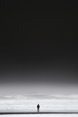 Solitary Figure Standing by the Vast Beach Under a Dark Sky