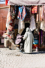 Market seller in Morocco not recognisable selling rugs on a street market.