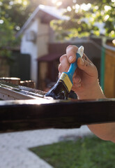 Painting brush on metal rod with black paint closeup