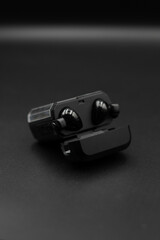 Black TWS earphones open with black background