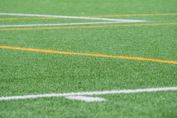 Obraz premium Bright green turf field with orange and white markings for sports activities