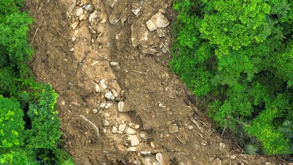 Bird’s eye shot capturing a landslide caused by natural disaster forces, exposing soil erosion...