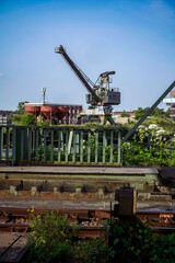 Industrial cityscape with crane and rails against a blue sky, view from the bascule bridge for...