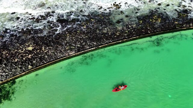 Drone clip of canoeists paddling in a green watered tidal pool in Cape Town South Africa