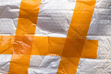 packaging film with bubbles, rewound with orange tape, texture