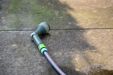 Garden Hose and Nozzle on a Concrete Patio