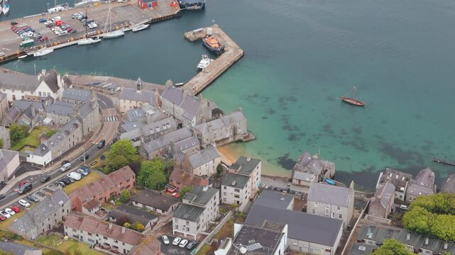 An aerial shot of the harbour town of Lerwick, Shetland in Scotland, sweeping over town area and beach.