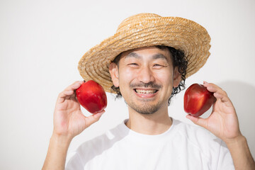 収穫したりんごを持つ男性のイメージ　カメラ目線の笑顔...