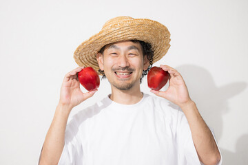 収穫したりんごを持つ男性のイメージ　カメラ目線の笑顔...