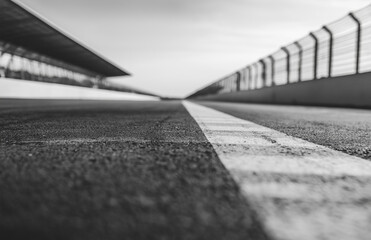 A black and white photograph of the finish line at an empty race track