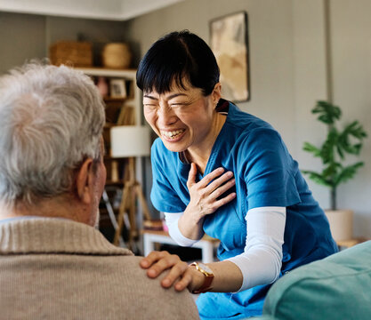 Portrait of a doctor or nurse caregiver supporting senior man, hand on the shoulder care and hug at home or nursing home