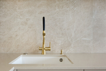 Modern kitchen faucet design with gold finish and minimalist aesthetic in bright interior space