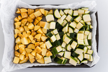 oven tray with cubed baby potatoes and zucchini ready for roasting