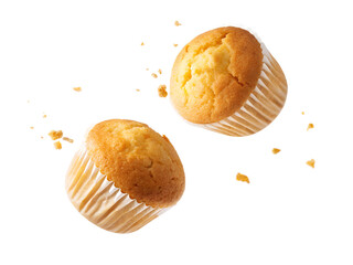 Delicious muffins are flying through air, showcasing their golden tops and fluffy texture, perfect for any sweet treat lover