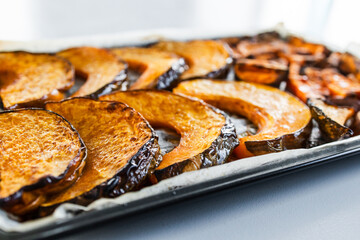 roasted kent pumpkin slices and sweet potato chips on an oven tray