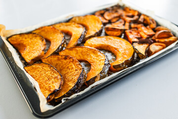 roasted kent pumpkin slices and sweet potato chips on an oven tray
