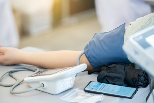 Close-up of nurse measuring blood pressure with sphygmomanometer during medical checkup
