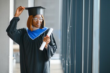 beautiful young afro american graduate holding diploma
