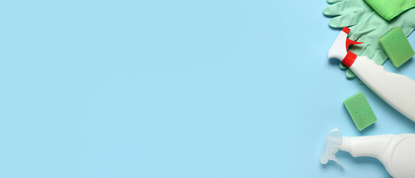 Set of cleaning supplies and bottle of detergent on blue background - Powered by Adobe