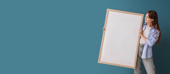 Young woman with picture on blue background with space for text. Mockup for design
