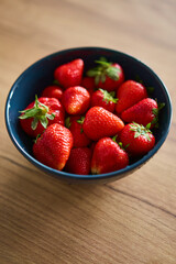 A beautifully vibrant bowl filled with fresh strawberries, showcasing their rich color, sweetness, and natural allure