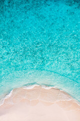 Aerial drone view of pristine tropical beach with soft white sand turquoise calm sea gentle waves bright sunny sky and lush green coastline perfect summer vacation tropical paradise travel destination