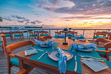 Outstanding overwater restaurant with dinner tables set for romantic luxury dining under amazing...