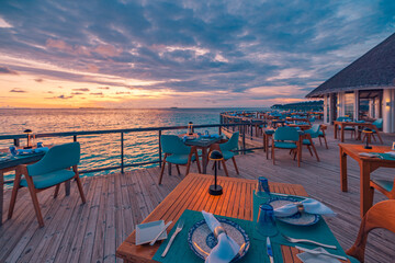 Outstanding overwater restaurant with dinner tables set for romantic luxury dining under amazing...