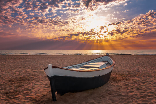 barca varada en la arena de la playa de la Malvarrosa, Valencia, Espa&ntilde;a, al amanecer