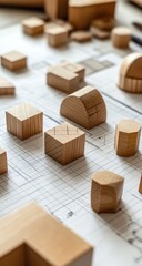 Light-colored wooden shapes on architectural blueprints