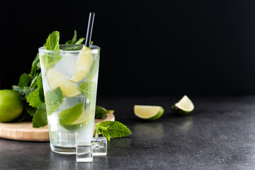 Classic Mojito Cocktail with Lime and Mint on black slate background. Copy space