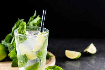 Classic Mojito Cocktail with Lime and Mint on black slate background. Copy space