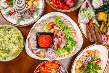 Traditional Eastern European appetizer platter with assorted meats, pickled vegetables, herring, fresh cabbage salad, mushrooms, and dipping sauces arranged for a festive meal setting