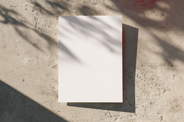 A white A1 size poster mockup on a on a raw concrete background with soft shadows.