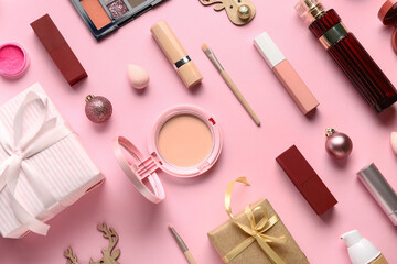 Naklejka premium Christmas composition with different makeup products and gift box on pink background