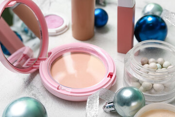 Makeup products with Christmas decor on white grunge background
