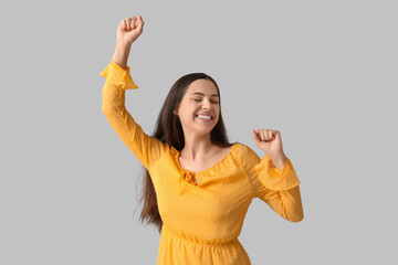 Cheerful young woman on grey background