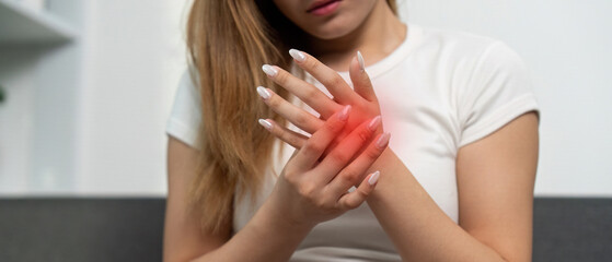 Hand Pain and Discomfort. Young woman experiencing wrist pain at home.