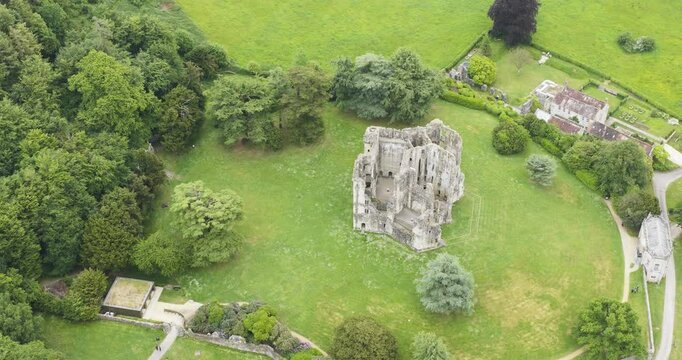 Old Wardour Castle ruins surrounded by bright green fields and forest, High angle aerial view