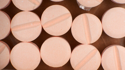 A close-up of various unpackaged pills neatly arranged in a box. The photograph symbolizes medicine, treatment, health, and addictions.