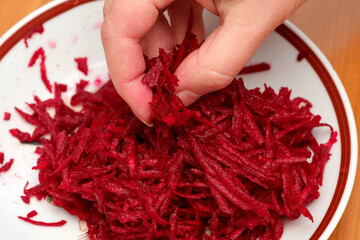 Grating vibrant beets in a rustic kitchen for healthy dishes