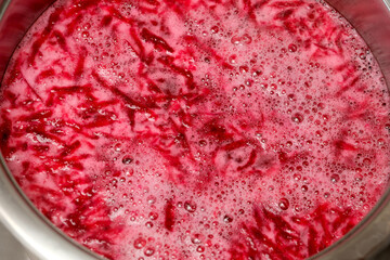 Beetroot juice bubbles in a pot at a cozy kitchen gathering